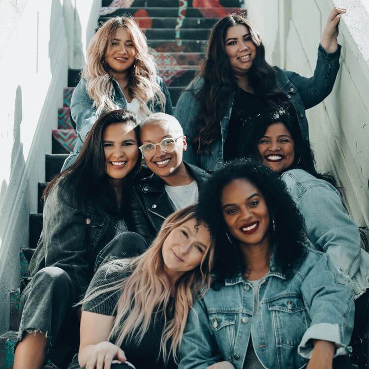 group of mixed women sitting on stairs