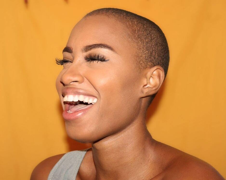 black woman laughing with closed eyes and lash extensions