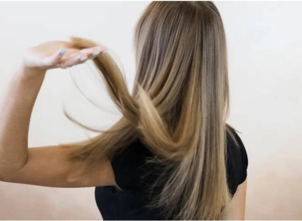 woman flipping her long clean blonde hair