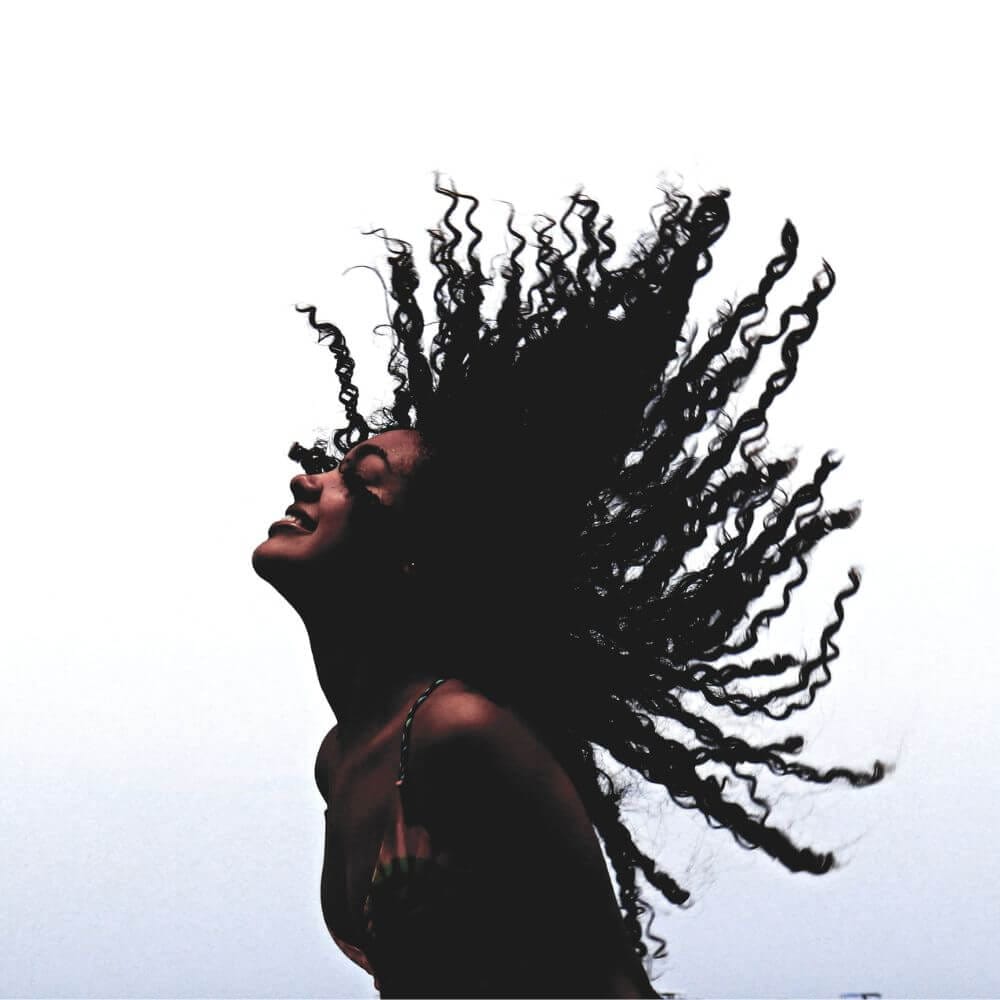 black woman with water weave hair flipping it back