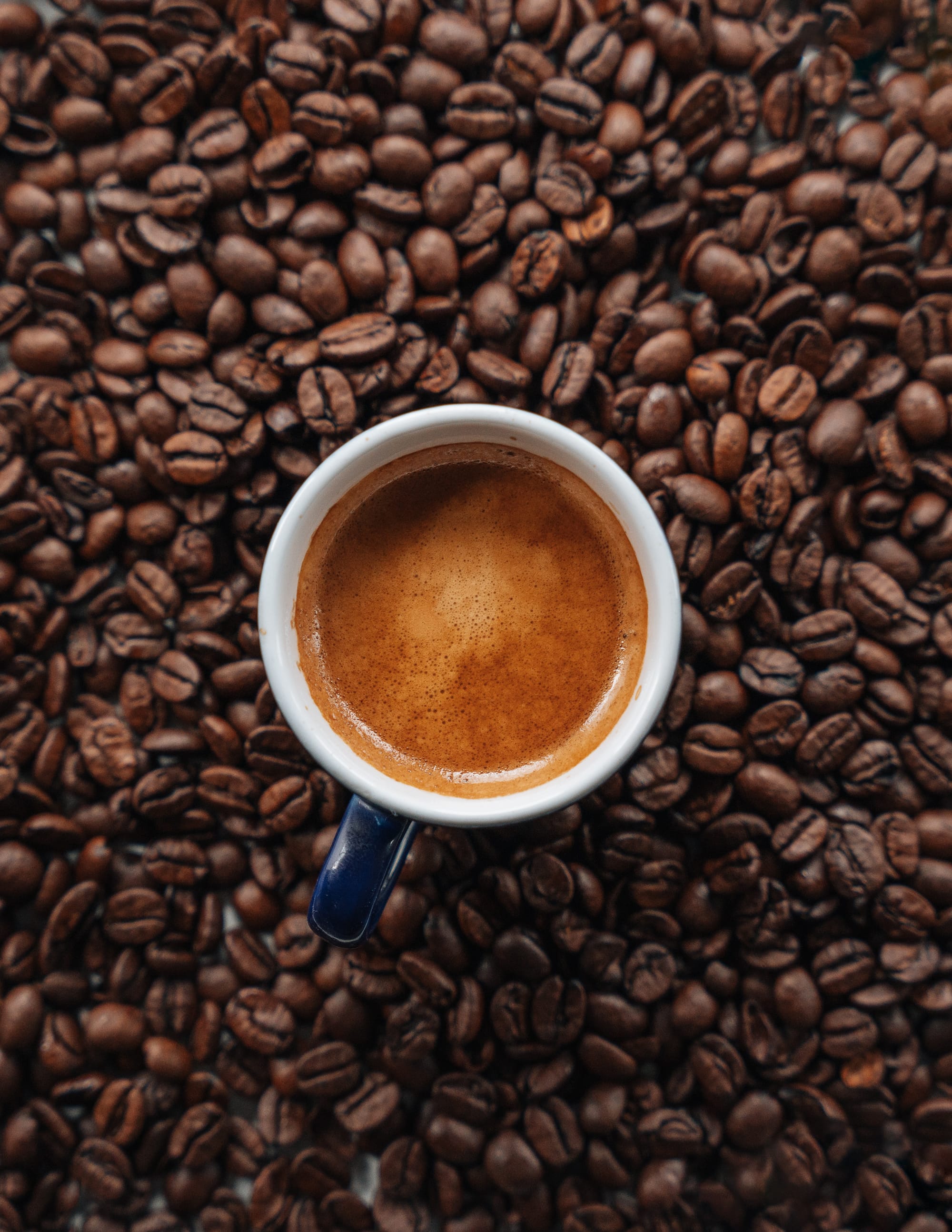 cup of espresso over coffee beans