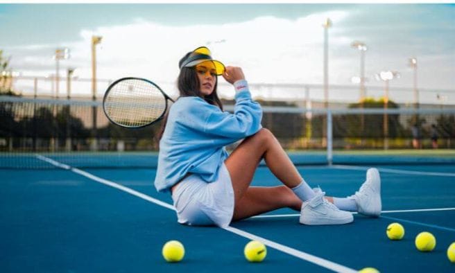 girl sitting on pickleball court with balls and racqet