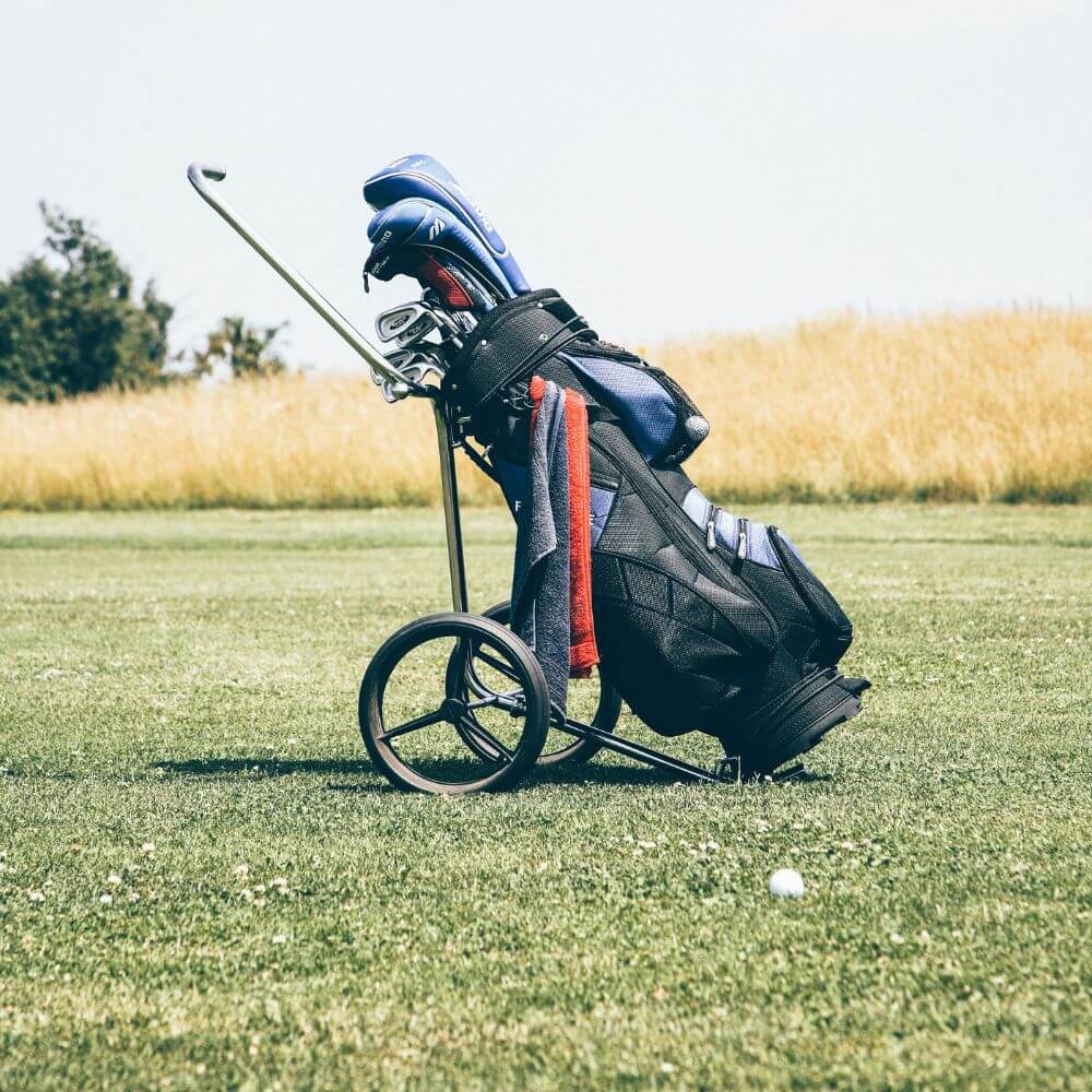 push cart with black golf bag in fairway